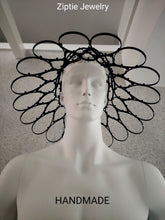 Load image into Gallery viewer, A black metal headpiece with an intricate web-like circular design, displayed on a white mannequin head. The text 'Ziptie Jewelry' is visible at the top and 'HANDMADE' at the bottom.
